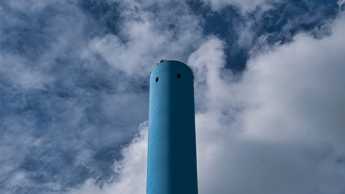 Industrial flue stack against a cloudy sky