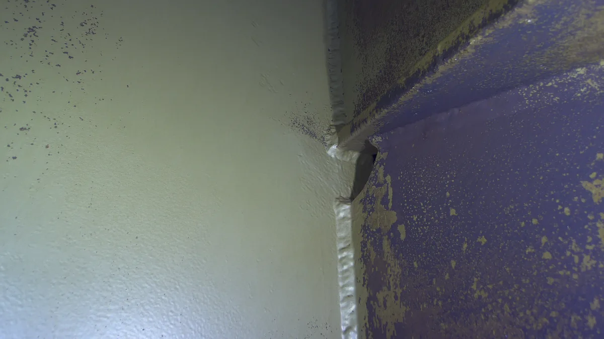 3.5× optical zoom of the same corner — the weld toe and drain-hole edge resolved for crack assessment