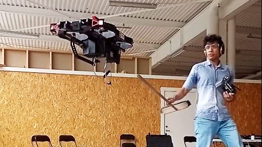 Man poking hovering drone with a stick