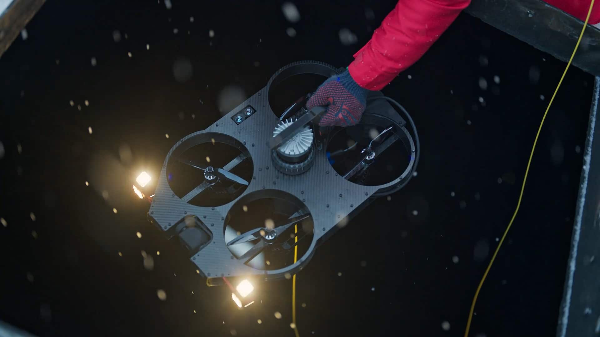 Quadcopter drone lowered into a dark hole