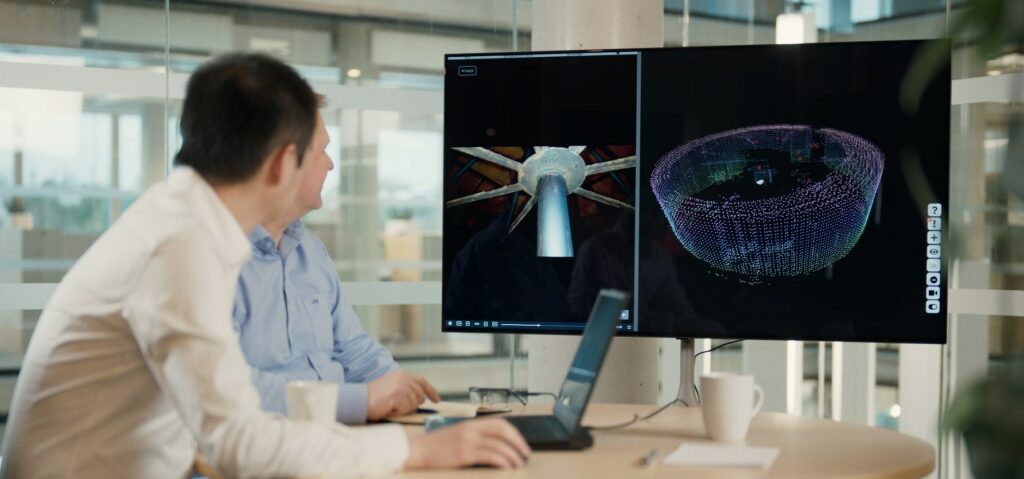 Man looking at computer screen with 3D graphics